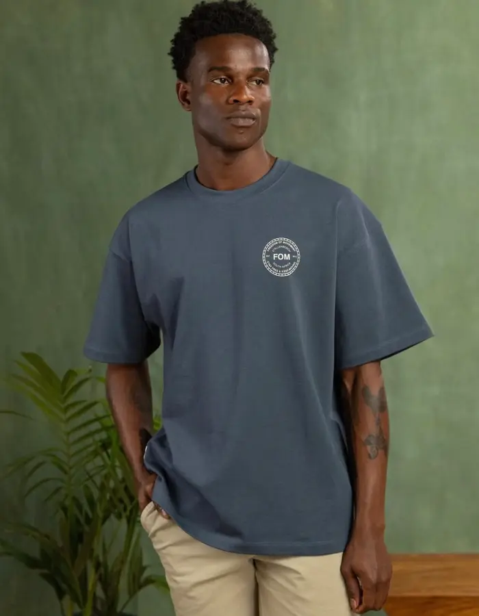 A man in a gray tee with the FOM crest on the chest