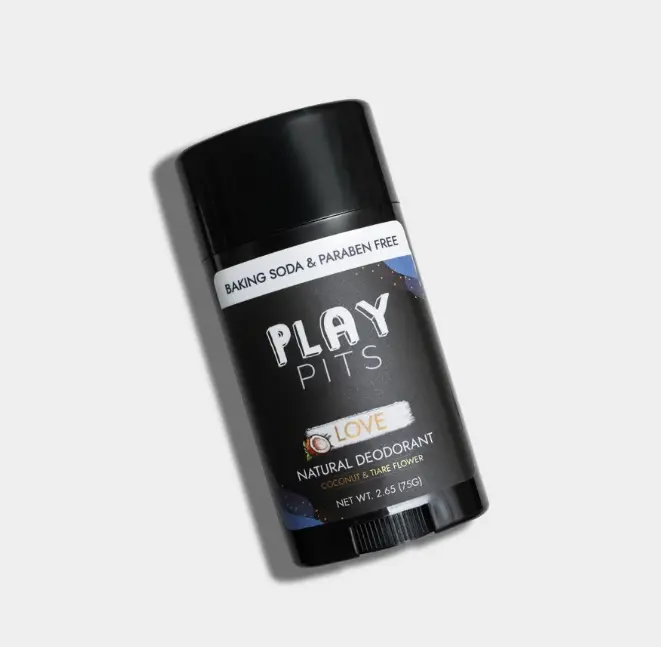 A black Play Pits Love natural deodorant stick on a gray background