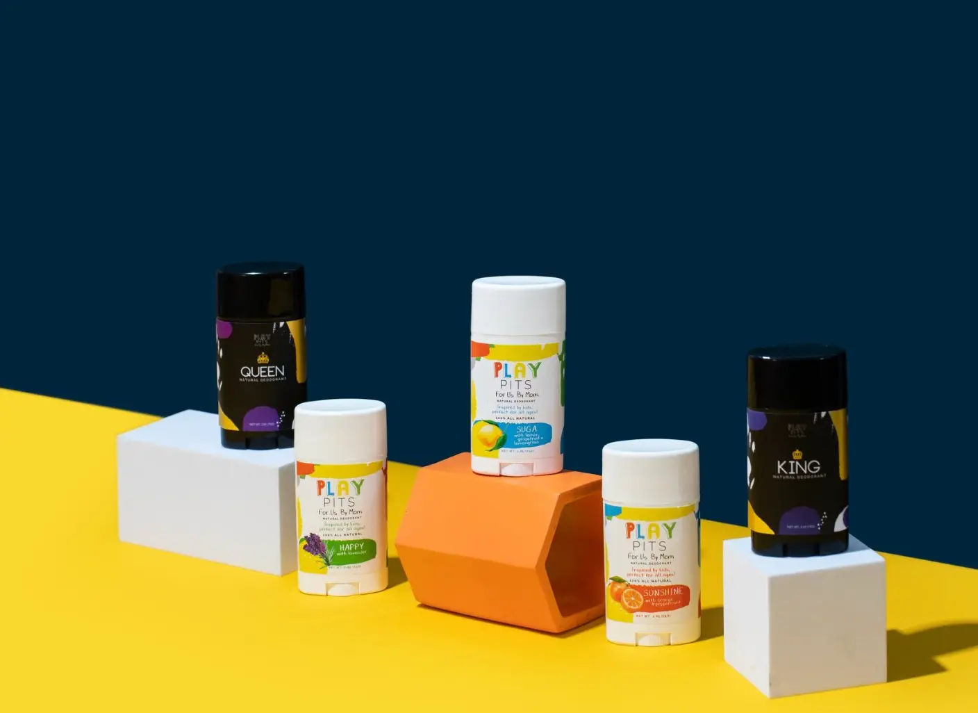 Play Pits Queen, Happy, Suga, Sonshine and King deodorants on yellow, white and orange blocks